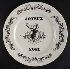 a white and black plate with an image of a deer head on the side, saying joyeux noel