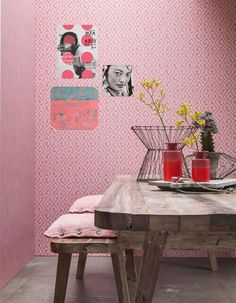 a dining room with pink wallpaper and wooden table