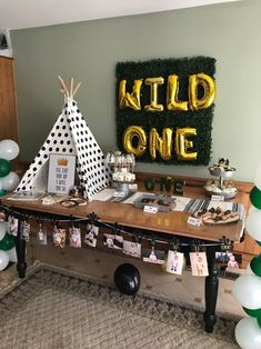 a party table with balloons and decorations for a kid's one year old birthday