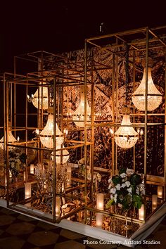 a room filled with lots of candles and chandeliers on top of a checkered floor