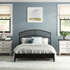 a bedroom with blue walls and white furniture