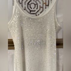 a white tank top with sequins on it