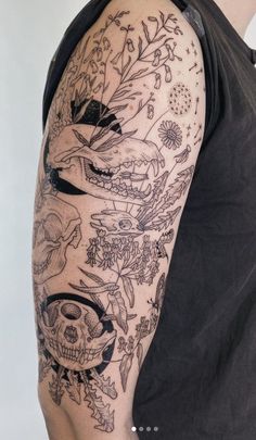 a man's arm with tattoos on it and an image of flowers, leaves and skulls