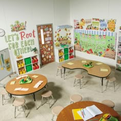 a classroom with tables, chairs and bookshelves full of children's artwork