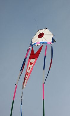 a kite flying high in the sky on a clear day with blue skies behind it