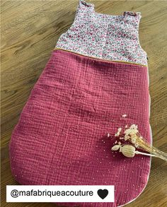 a pink sleeping bag with flowers on it and a spoon in the pocket next to it