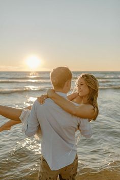 a man carrying a woman on his back at the beach