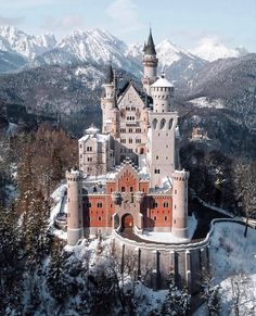 an aerial view of a castle in the mountains with snow on it's ground