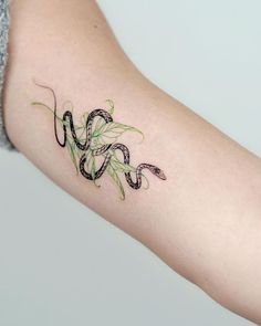 a woman's arm with a snake tattoo on it