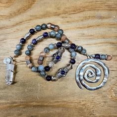 a wooden table topped with lots of beads and charms