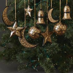 an ornament hanging from a christmas tree decorated with gold stars and crescents