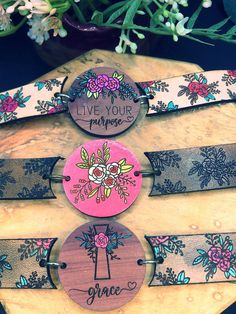 three wooden bracelets with flowers on them and the words live your purpose printed on them