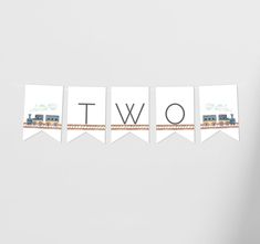 a train themed banner with the word two hanging from it's sides on a white wall