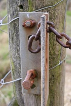 an old lock is attached to a wooden post