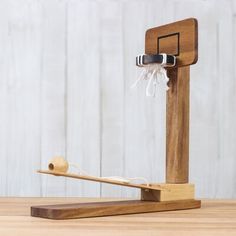 a wooden basketball hoop with a ball in it and a piece of string attached to the rim