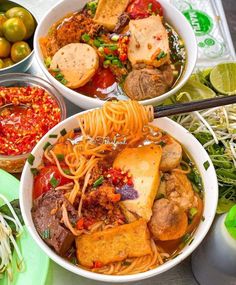 three bowls filled with different types of food on top of a table next to limes