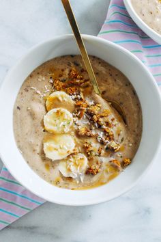 two bowls filled with oatmeal and bananas on top of a striped napkin