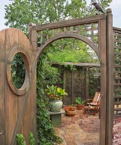 an outdoor garden with a wooden gate and potted plants