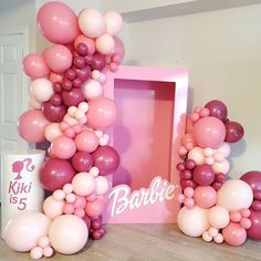 balloons are arranged in the shape of an arch for a baby's first birthday