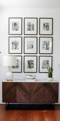 a living room with pictures on the wall and a sideboard in front of it