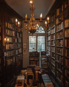 a chandelier hanging from the ceiling in a library filled with books