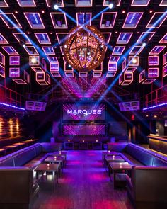 the marquee nightclub is lit up with purple and blue lights, as well as wooden benches