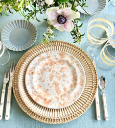 a table set with plates, silverware and flowers