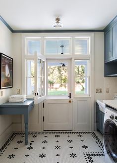 a washer and dryer in a small room with blue cabinets on the walls