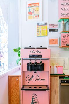 a pink ice cream machine sitting in front of a window