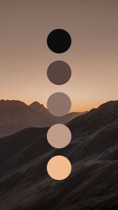 an image of the sun setting over mountains with circles in front of it and below them