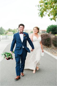 a bride and groom walking down the street