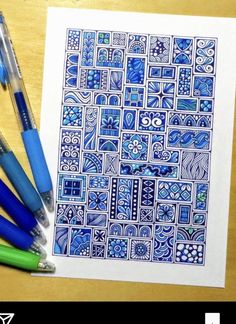 some pens are sitting on top of a paper with blue and white tiles in it