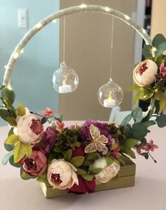 an arrangement of flowers and greenery is displayed in front of a mirror on a table