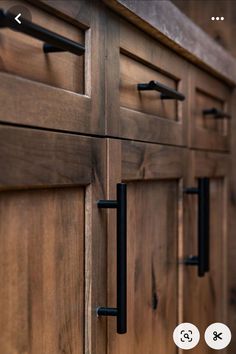 an image of wooden cabinets with black handles