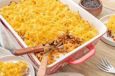 a casserole dish with cheese and meat in it on a table next to other dishes