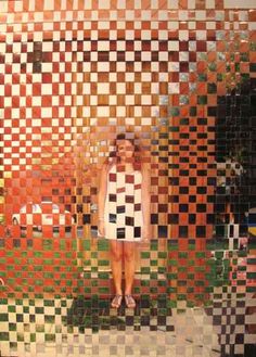 a woman standing in front of a mosaic wall