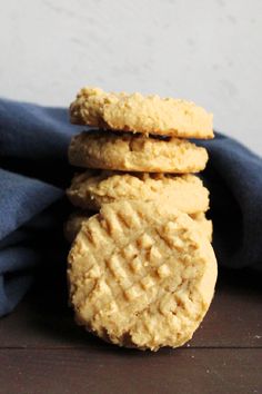 peanut butter cookies stacked on top of each other in front of a blue napkin with text overlay