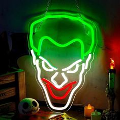 the joker mask is lit up with neon green and red lights, while it sits on top of a table