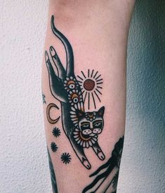 an animal tattoo on the leg of a person with sun and stars in it's eyes