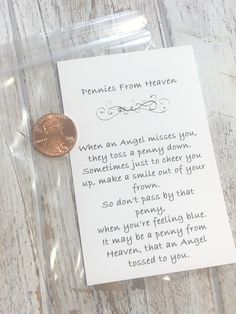 a penny sitting on top of a wooden table next to a note