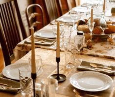 the table is set with plates, silverware and candlesticks for an elegant dinner