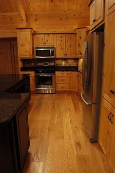 a kitchen with wood floors and stainless steel appliances