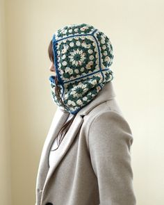 a woman wearing a green and white flowered hat