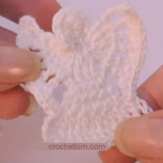 someone crocheting a piece of white yarn with their fingers and thumbnails