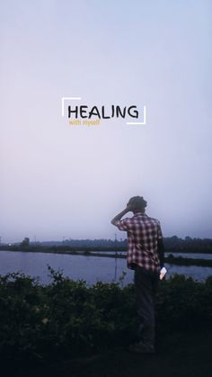 a man standing in front of a body of water with the words healing above him