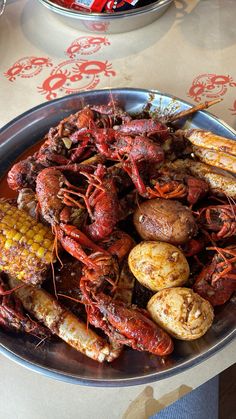 a plate full of cooked lobsters and corn on the cob