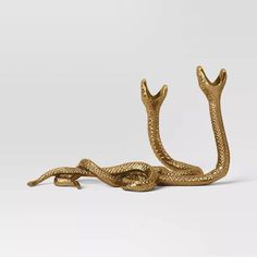 a gold snake figurine sitting on top of a white surface