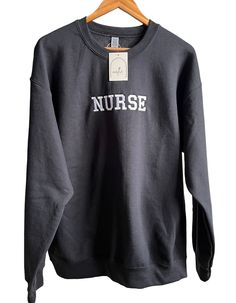 Embroidered NURSE Sweatshirt, Nurse Crewneck, Sweater, RN Sweatshirt, Graduate Nurse, Nursing, Registered Nurse Sweatshirt, Nurse Apparel ITEM DESCRIPTION: This Embroidered NURSE Crewneck Sweater is a great way to add a special touch to your wardrobe. With its comfortable fit, you'll stay warm and stylish. Its quality embroidery adds a professional look and the variety of colors provides plenty of options for styling. -Embroidered Logo: 'NURSE'  -LOGO Size: Approximately 6.5in (width) x 1.75 in Crew Neck Top With Embroidered Text For College, Embroidered Crew Sweatshirt With Relaxed Fit, Embroidered Relaxed Fit College T-shirt, Embroidered Relaxed Fit Crew Sweatshirt, Relaxed Fit Embroidered Crew Sweatshirt, Embroidered Crew Neck Sweatshirt With Relaxed Fit, Embroidered Crew Neck Sweatshirt In Relaxed Fit, Embroidered Relaxed Fit Sweatshirt For College, Embroidered Relaxed Fit Crew Neck Sweater