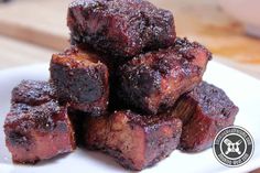 small cubes of meat sitting on top of a white plate