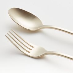 two forks and spoons on a white surface